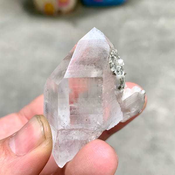Clear quartz prism with fluorite cube and chlorite on dolomite from Yaogangxian Mine, Hunan, close-up of the crystal faces