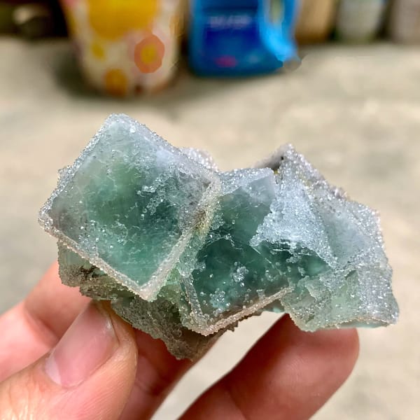 Three sugar-frosted green fluorite cubes from Fujian, China, held in hand