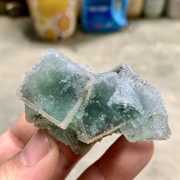 Three sugar-frosted green fluorite cubes from Fujian, China, detail of the matrix contact