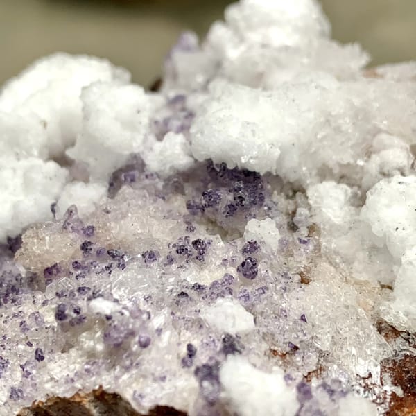 Purple yttrofluorite with white gypsum crust from Guizhou, China, close-up of the crystal faces