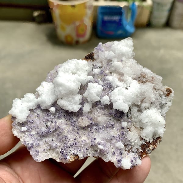 Purple yttrofluorite with white gypsum crust from Guizhou, China, detail of the matrix contact
