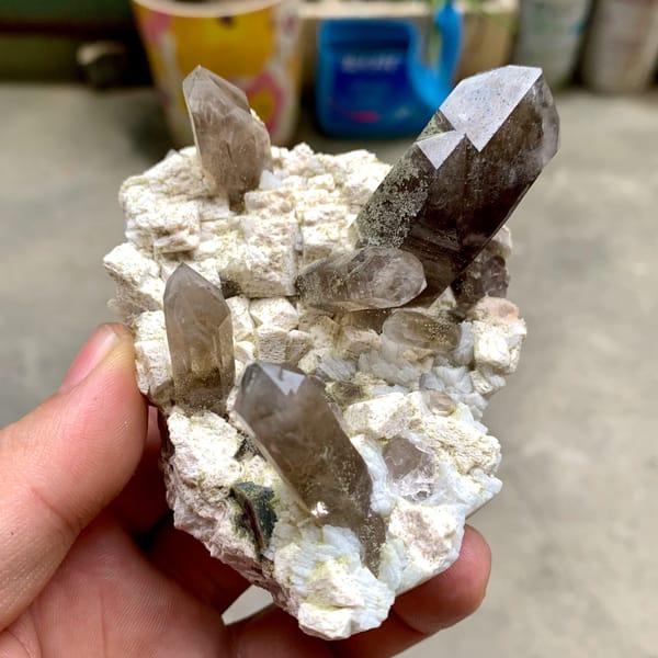 Smoky quartz points with chlorite on cream feldspar from Fujian, China, top view