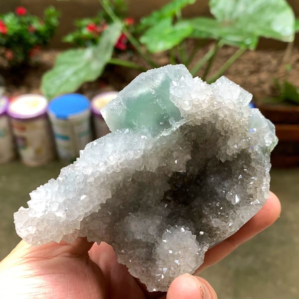 Bright green fluorite cube on sparkling quartz druse from Fujian, China, top view