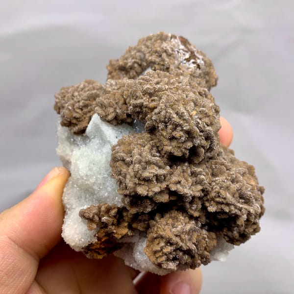 Chocolate-brown calcite over white sugar fluorite from Fujian, China, close-up of the crystal faces