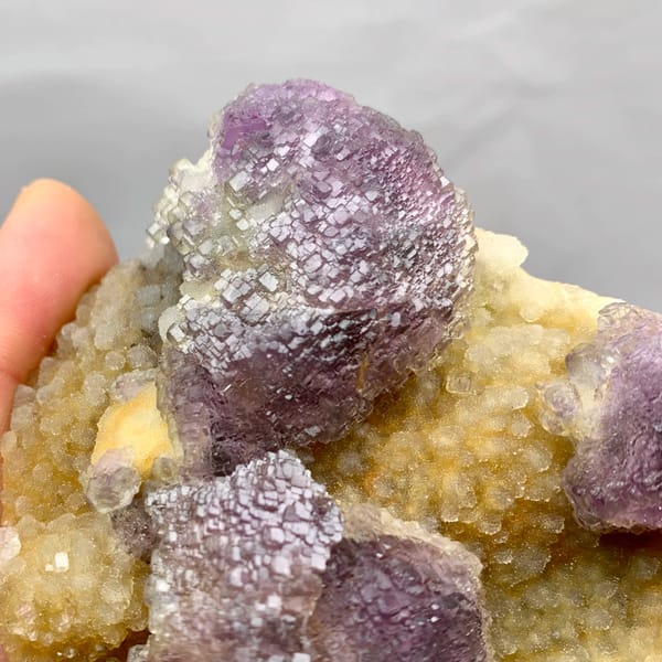 Purple mosaic fluorite balls on golden quartz druse from Fujian, China, reverse side