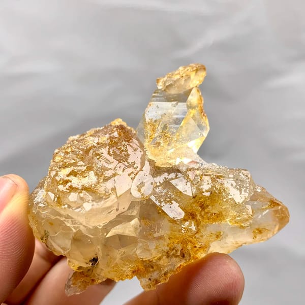 Golden natural citrine quartz floater from Guangdong, China, held in hand