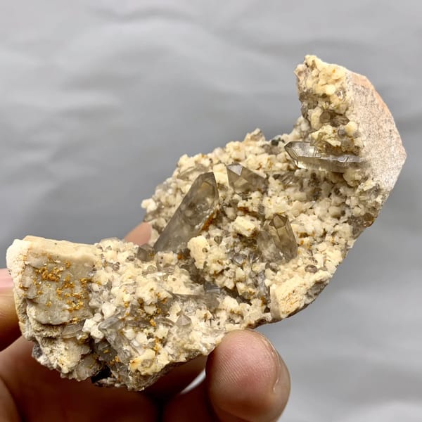 Smoky quartz points in hollow of cream feldspar from Fujian, China, close-up of the crystal faces