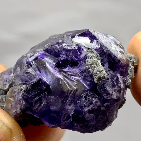 Tadpole-shaped violet fluorite floater with grey quartz from Fujian, China, close-up of the crystal faces