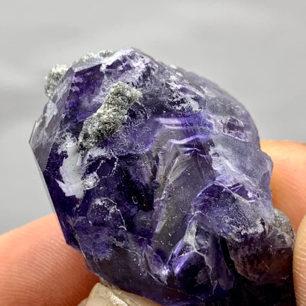 Tadpole-shaped violet fluorite floater with grey quartz from Fujian, China, top view
