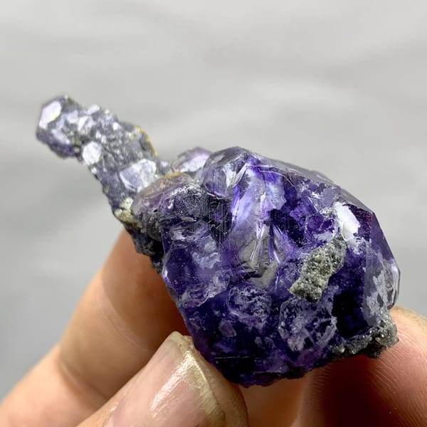 Tadpole-shaped violet fluorite floater with grey quartz from Fujian, China, detail of the matrix contact