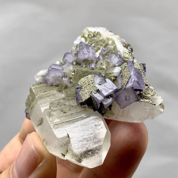 Purple fluorite cubes with pyrite on clear quartz from Yaogangxian Mine, Hunan, China, close-up of the crystal faces