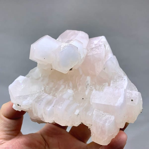 Soft pink calcite crystals with pyrite from Fujian, China, held in hand