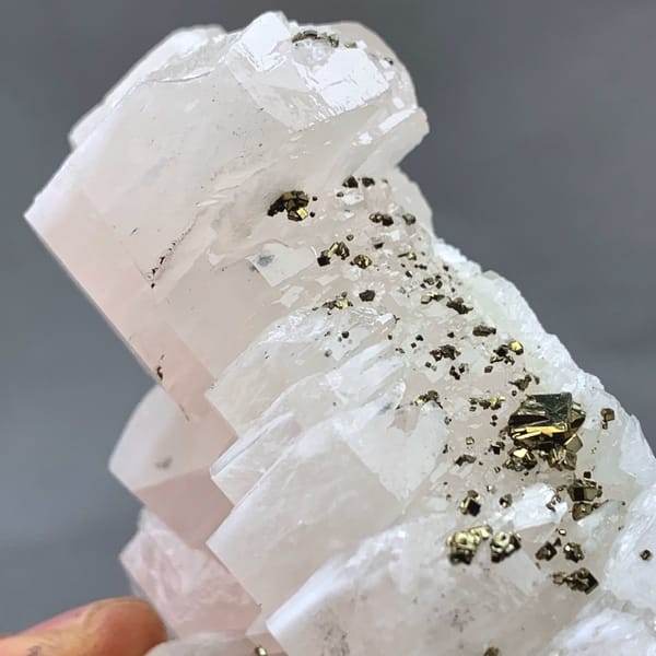 Soft pink calcite crystals with pyrite from Fujian, China, close-up of the crystal faces