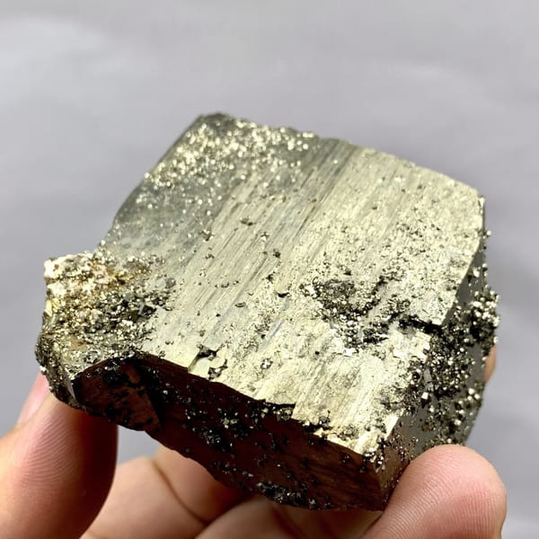 Heavy brass-gold pyrite block with striated faces from Yaogangxian Mine, Hunan, China, detail of the matrix contact