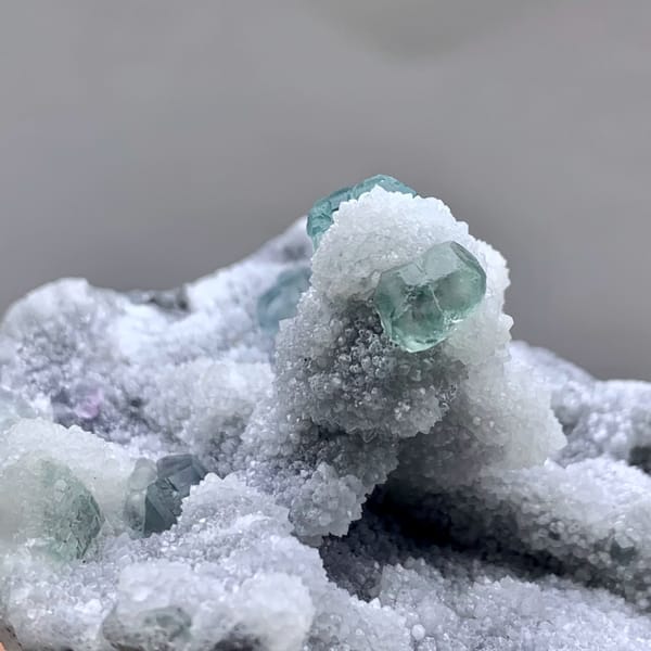 Blue-green fluorite cubes on frosted lavender and white mound from Fujian, China, top view