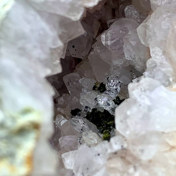 Pale lilac quartz geode with green epidote from Sichuan, China, close-up of the crystal faces