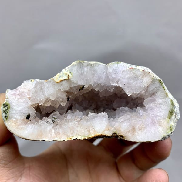 Pale lilac quartz geode with green epidote from Sichuan, China, detail of the matrix contact