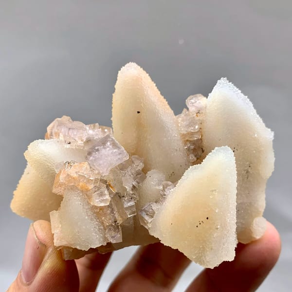 Peach-toned quartz pseudomorphs after calcite from Zhejiang, China, held in hand