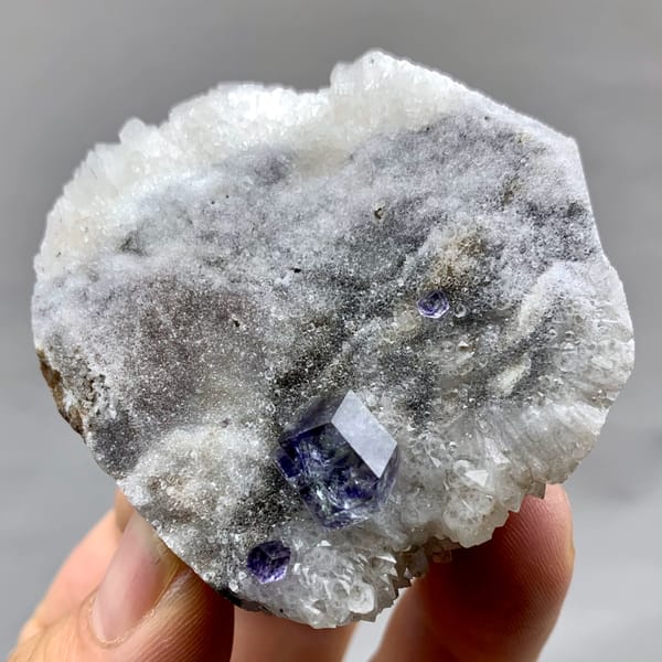 Single blue fluorite crystal on grey quartz druse from Fujian, China, top view