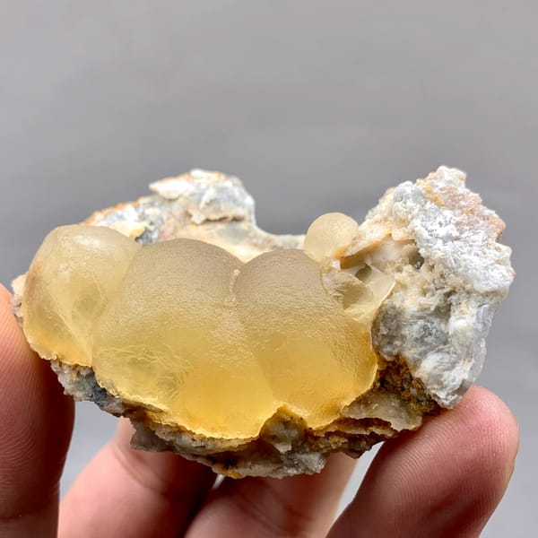 Large honey-yellow botryoidal fluorite ball on grey matrix from Henan, China, second angle