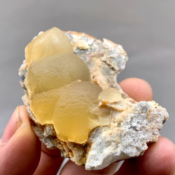 Large honey-yellow botryoidal fluorite ball on grey matrix from Henan, China, close-up of the crystal faces