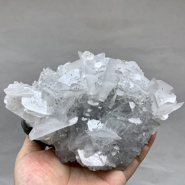 Large plate of glassy calcite blades with pyrite from Xianghualing, Hunan, China, detail of the matrix contact