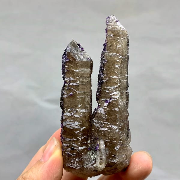 Two tea-brown quartz prisms with purple fluorite caps from Inner Mongolia, China, top view