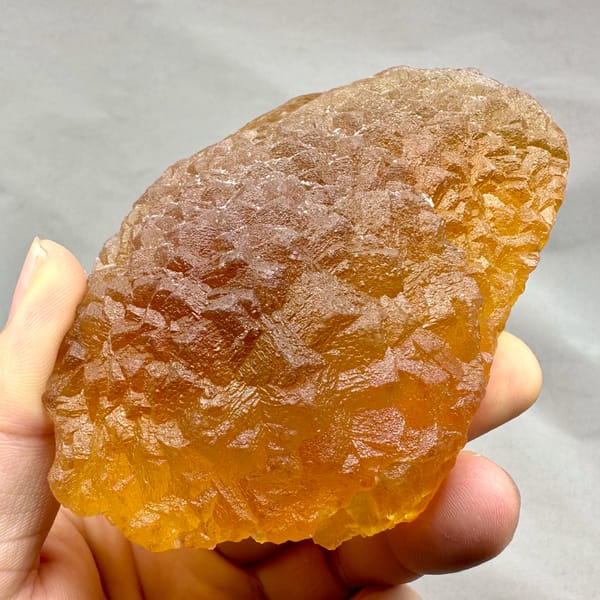 Amber-yellow translucent fluorite block from Zhejiang, China, close-up of the crystal faces