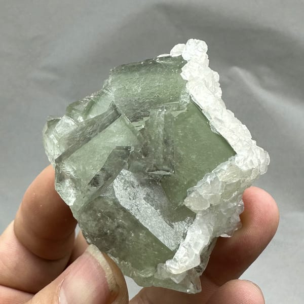 Glassy green fluorite block rimmed with white calcite from Xianghualing, Hunan, China, second angle