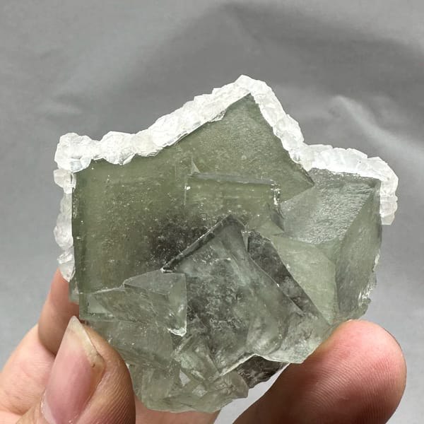 Glassy green fluorite block rimmed with white calcite from Xianghualing, Hunan, China, reverse side