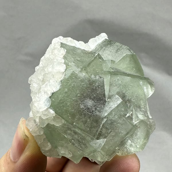 Glassy green fluorite block rimmed with white calcite from Xianghualing, Hunan, China, top view