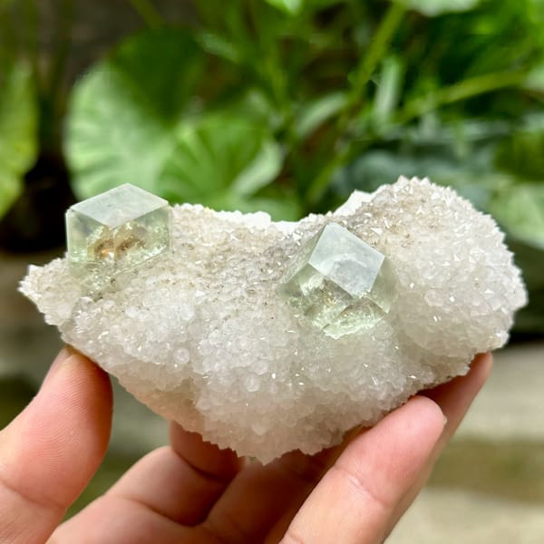 Two transparent green dodecahedral fluorite crystals on white quartz from Fujian, China