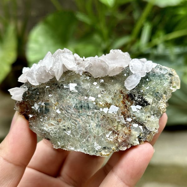 Glassy green fluorite cubes with white calcite and pyrolusite from Xianghualing, Hunan, China, detail of the matrix contact