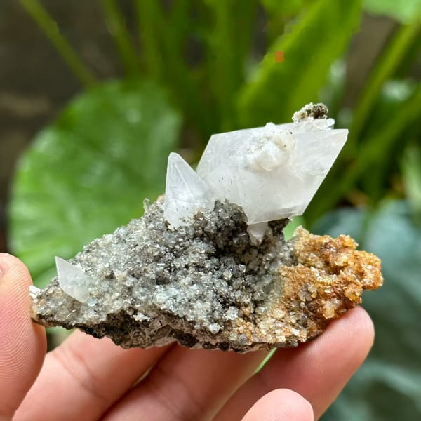 Double-terminated calcite crystal with fluorite octahedra on druse from Fujian, China