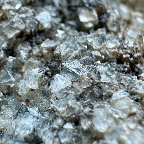 Double-terminated calcite crystal with fluorite octahedra on druse from Fujian, China, top view