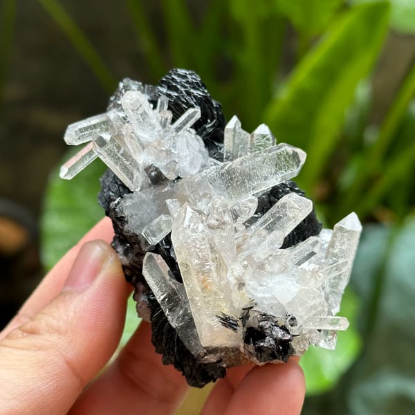 Etched clear quartz prisms on black specular hematite from Guangdong, China, top view