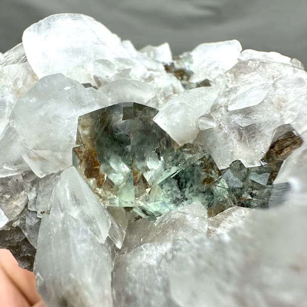 White calcite blades over glassy green fluorite from Xianghualing, Hunan, China, close-up of the crystal faces