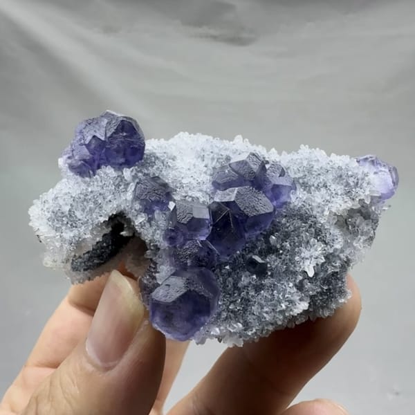 Violet-blue fluorite cubes on sparkling grey quartz from Fujian, China, detail of the matrix contact