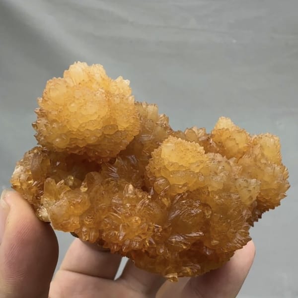 Golden-yellow botryoidal calcite balls from Guizhou, China, detail of the matrix contact