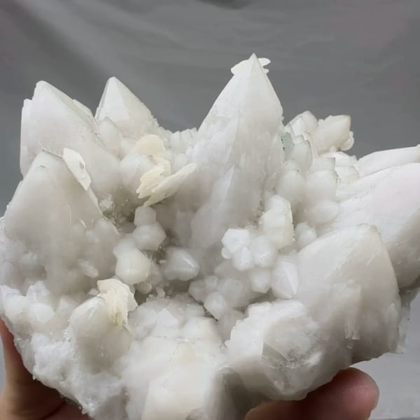 Chunky white quartz cluster with calcite from Xianghualing, Hunan, China, close-up of the crystal faces