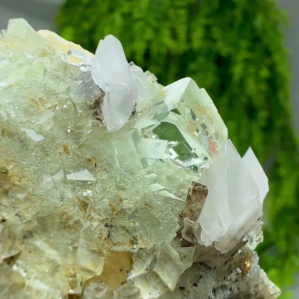 White calcite crystal on glassy green fluorite with pyrolusite from Xianghualing, Hunan, China, close-up of the crystal faces