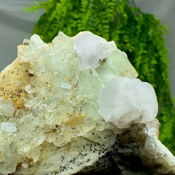 White calcite crystal on glassy green fluorite with pyrolusite from Xianghualing, Hunan, China, top view