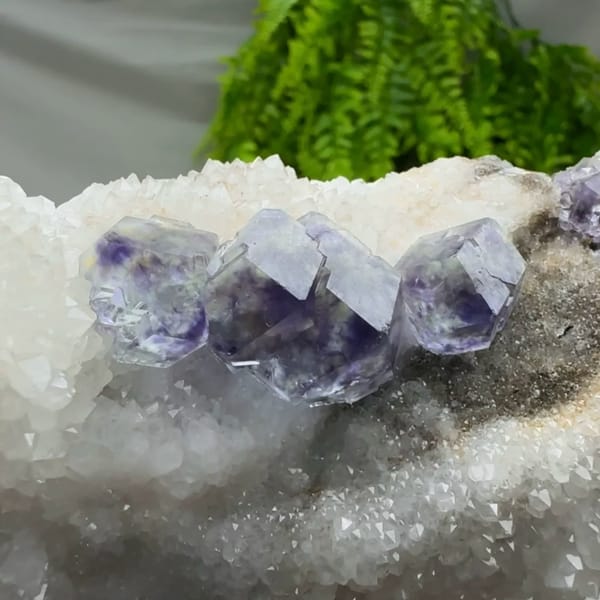 Deep purple dodecahedral fluorite on white quartz plate from Fujian, China, top view