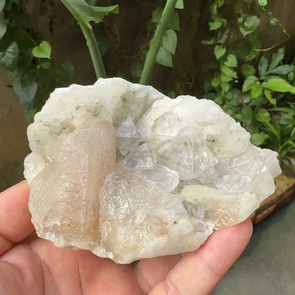 White fluorite octahedra with calcite prism and quartz from Inner Mongolia, China, held in hand