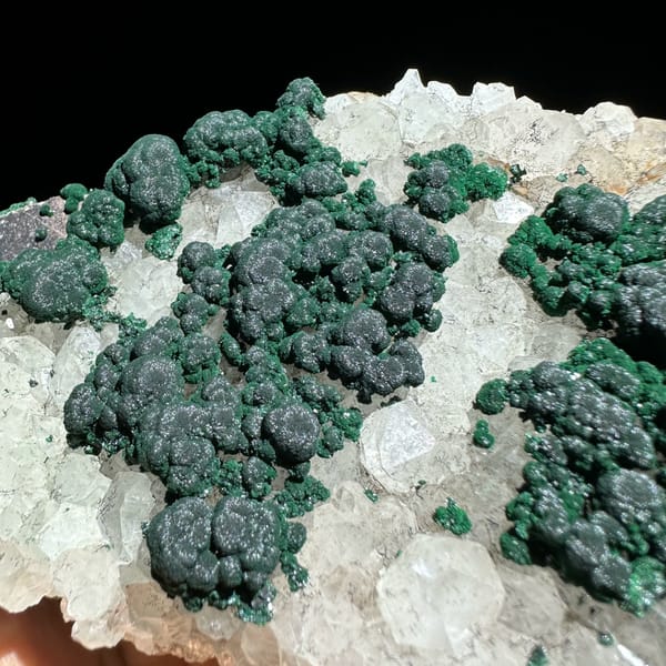 Green malachite islands on white quartz plate from Laos, close-up of the crystal faces