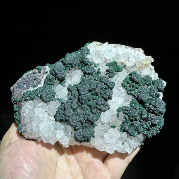 Green malachite islands on white quartz plate from Laos, top view