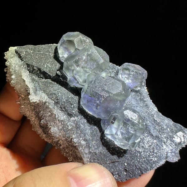 Blue-cored fluorite cubes on grey quartz druse from Fujian, China, close-up of the crystal faces