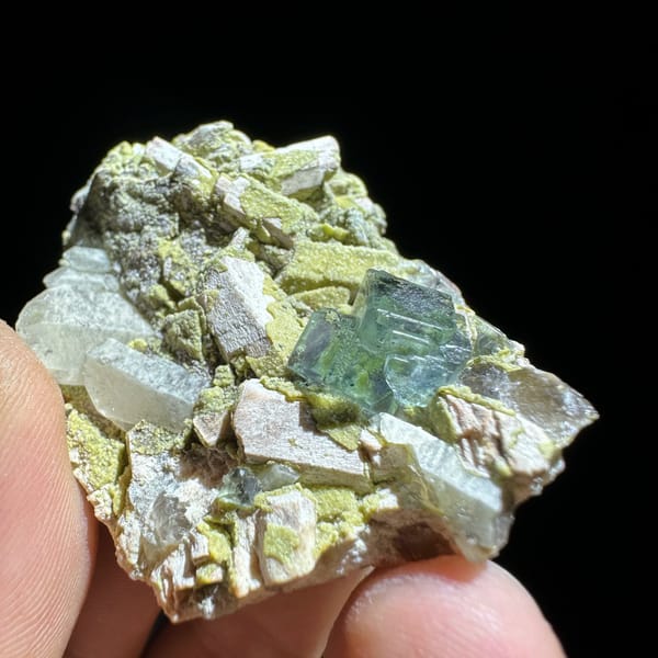 Green fluorite octahedron on yellow-green mica and feldspar from Yunxiao, Fujian, China, close-up of the crystal faces