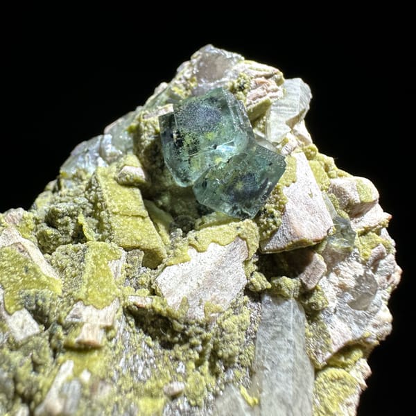 Green fluorite octahedron on yellow-green mica and feldspar from Yunxiao, Fujian, China, top view