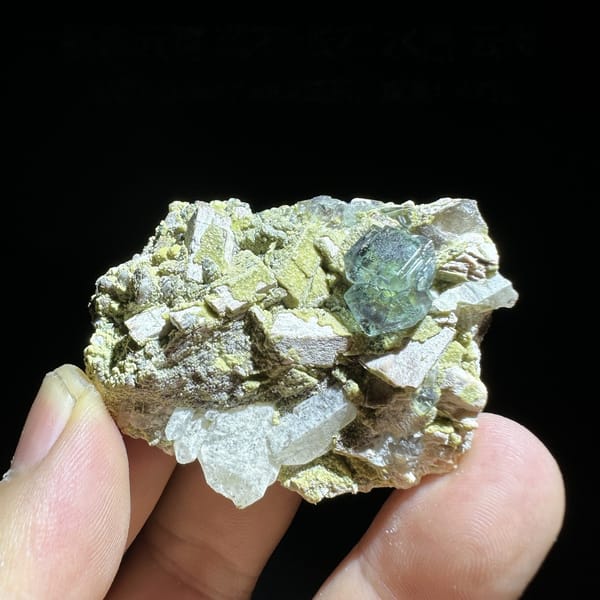 Green fluorite octahedron on yellow-green mica and feldspar from Yunxiao, Fujian, China, detail of the matrix contact